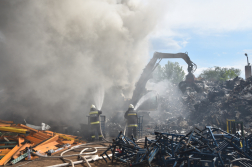 Tűzoltók oltják a felhalmozott hulladékot munkagép segítségével
