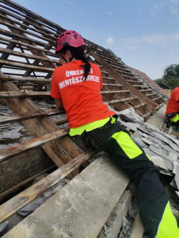 Önkéntes tűzoltó segít az ideiglenes helyreállítási munkákban a viharkárt szenvedett Sellye településen
